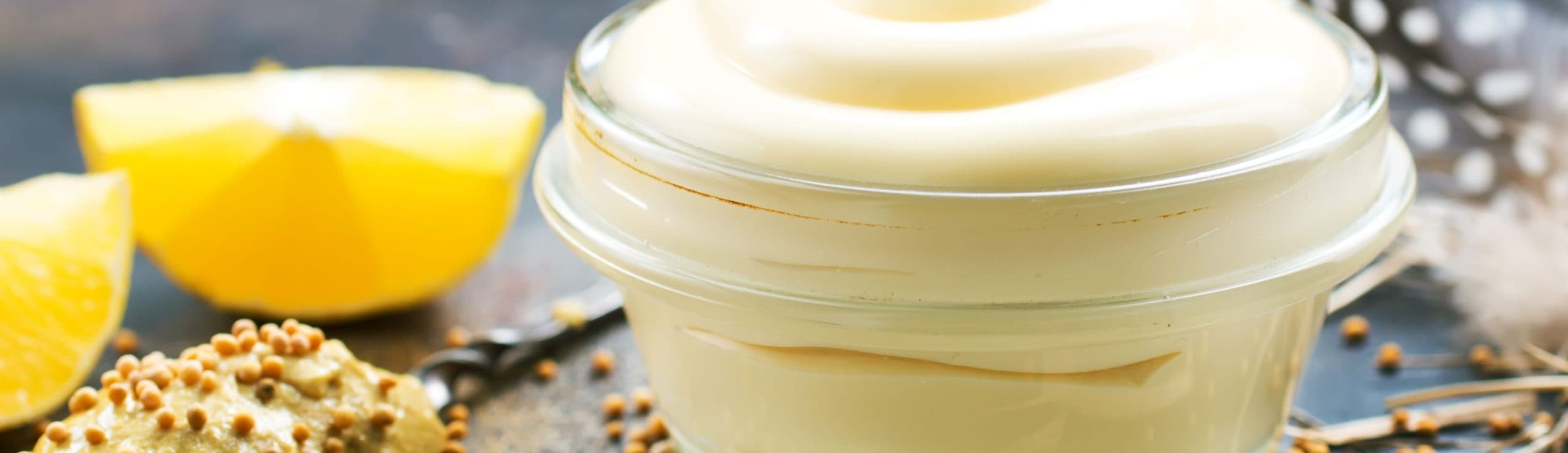 A jar of mayo and 2 pieces of citrus fruit